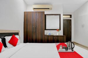 a bedroom with a large white bed with red pillows at Super OYO Flagship 93079 Hotel Paradise in Varanasi