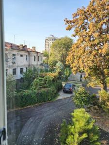 a car parked on a street with trees and buildings at Апартаменты in Tashkent