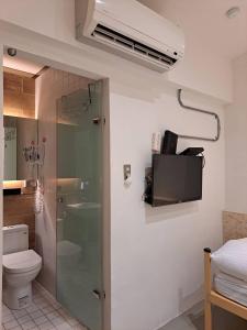 a bathroom with a shower and a toilet and a sink at King Wow Inn in Tainan