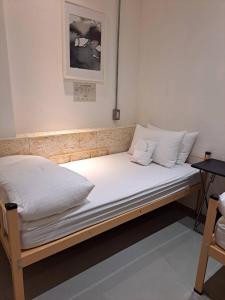a bed with white sheets and pillows on it at King Wow Inn in Tainan