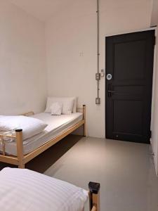 a room with two beds and a black door at King Wow Inn in Tainan