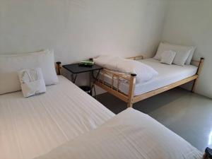 two twin beds in a room with a table at King Wow Inn in Tainan
