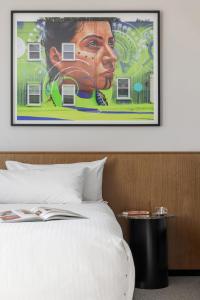 a painting of a woman is above a bed at Art Series - The Adnate in Perth