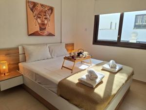 1 dormitorio con 1 cama y toallas en una mesa en Paramount Gardens Resorts D204, en Tersephanou