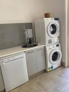 a kitchen with a washing machine and a sink at Casa de Palmas Noosa in Noosaville