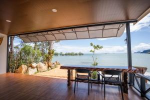 クラビタウンにあるBeachHouse Pool Villas Krabiのテーブルと椅子、水辺の景色を望むバルコニー