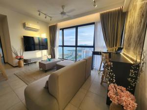 Urban Suites - Penang في Jelutong: غرفة معيشة مع أريكة ونافذة كبيرة