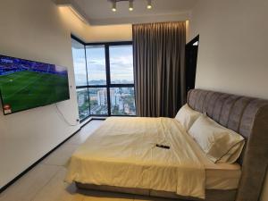 Urban Suites - Penang في Jelutong: غرفة نوم بسرير وتلفزيون وأريكة