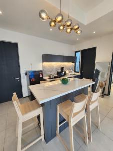 a kitchen with a large island with chairs around it at Urban Suites - Penang in Jelutong