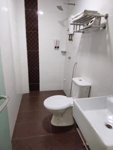 a white bathroom with a toilet and a sink at Fortune Hotel in Johor Bahru