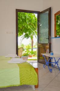 a bedroom with a bed and a table and a window at Studios Ifigenia in Skala Potamias