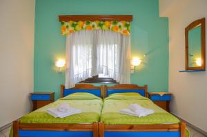 a bedroom with a bed with two towels on it at Studios Ifigenia in Skala Potamias