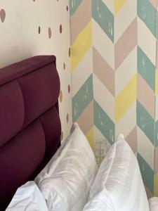 1 dormitorio con 1 cama y pared multicolores en Tasteful Timeless Paradise Eternity Wedding 住进幸福里～, en Shah Alam