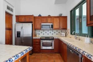 a kitchen with wooden cabinets and stainless steel appliances at Ocean View 4Bd Penthouse Wyndham Spectacular View near El Yunque Forest in Rio Grande