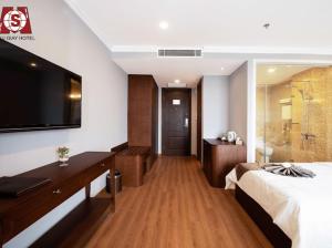 a hotel room with a bed and a flat screen tv at Cầu Giấy Hotel -110 đường Cầu Giấy - by Bay Luxury in Hanoi
