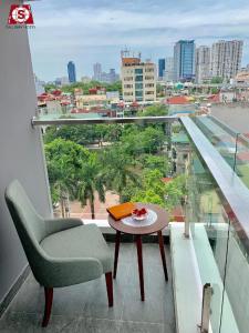 a balcony with a chair and a table and a view at Cầu Giấy Hotel -110 đường Cầu Giấy - by Bay Luxury in Hanoi