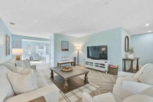 ブレーデントンにあるTranquil Breezeの白い家具と薄型テレビのあるリビングルーム
