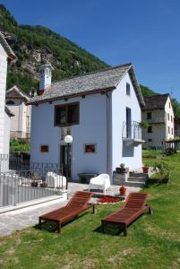 a white house with two benches in front of it at Ca' del Borgo in Cadarese