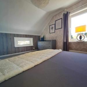 a large bed in a bedroom with a window at Liebevoll renoviertes Ferienhaus im schwedischen Lappland Västerbotten in Björksele