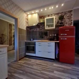 a kitchen with a red refrigerator and white cabinets at Liebevoll renoviertes Ferienhaus im schwedischen Lappland 