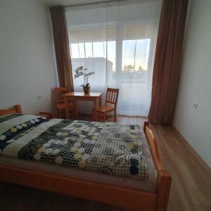 1 dormitorio con cama, mesa y ventana en Ubytovanie FUNSTAR Topoľčany, en Topoľčany