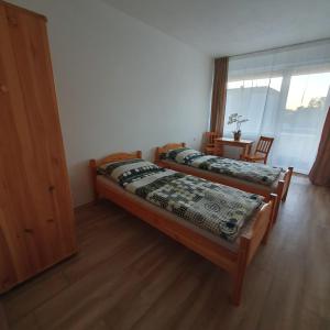 two beds in a room with a window at Ubytovanie FUNSTAR Topoľčany in Topoľčany