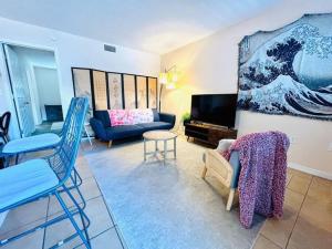 uma sala de estar com um sofá azul e uma televisão em Walk to hospital near the beach em Sarasota