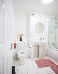 Baño blanco con aseo y lavamanos en Spacious House near Kings Cross en Londres