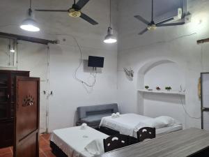 una habitación de hospital con 2 camas y una silla en Casa Faccioli, en Mompox