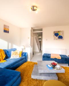 Spacious House near Kings Cross في لندن: غرفة معيشة مع أريكة زرقاء وطاولة