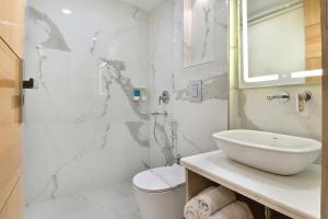 a white bathroom with a sink and a shower at Hotel Gold Palace - 03 Mins Walk From New Delhi Railway Station in New Delhi