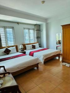twee bedden in een kamer met twee ramen bij Hoàng Gia Hotel - Số 39 ngõ 45 Trần Thái Tông - by Bay Luxury in Hanoi