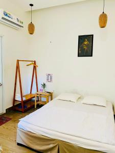 ein Schlafzimmer mit einem großen weißen Bett in einem Zimmer in der Unterkunft Homestay KV in Cần Thơ