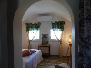 a bedroom with a bed and two windows at Gîte Abrest, 5 pièces, 8 personnes - FR-1-489-386 in Abrest