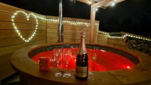 a bottle of wine sitting on a table with wine glasses at Chalet avec bain nordique in Durfort +4 photos