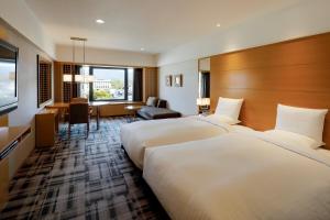 um quarto de hotel com duas camas e uma secretária em Kyoto Brighton Hotel em Quioto