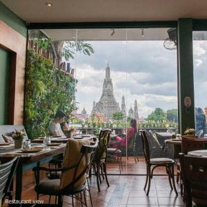 un restaurant avec vue sur les temples de Thailande dans l'établissement Sala Arun, à Bangkok