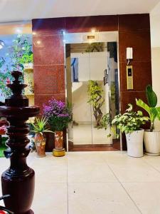 a room with potted plants and a doorway with a door with at Sao Mai Hotel - 35 Cổ Linh- by Bay Luxury 