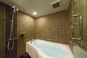 a bathroom with a tub and a soccer ball on the wall at Kyoto Brighton Hotel in Kyoto