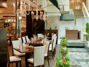 a restaurant with wooden tables and white chairs at Kyoto Brighton Hotel in Kyoto