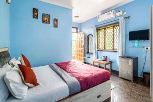 niebieska sypialnia z łóżkiem i telewizorem w obiekcie Last Minute Trip Hostel Morjim w mieście Morjim