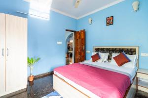 1 dormitorio con paredes azules y 1 cama con sábanas rosas en Last Minute Trip Hostel Morjim, en Morjim