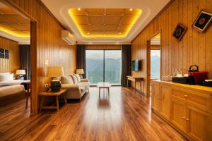 a living room with a couch and a bed and a table at Lady Hill Sapa Resort in Sa Pa