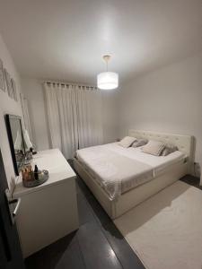 Dormitorio blanco con cama y mesa en Maison en bois , plein pieds,piscine privative en Lavelanet
