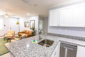 a kitchen with a sink and a living room at Fenced backyard, near Downtown in Sarasota