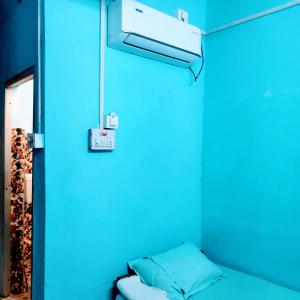 a blue room with a bed and a light at Hotel Shree Ram SIA Residency in Gaya