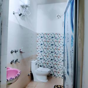 W łazience znajduje się toaleta i różowa umywalka. w obiekcie Hotel Shree Ram SIA Residency w mieście Gaja