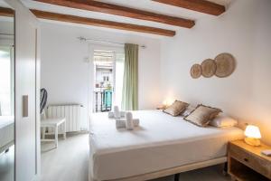 - une chambre blanche avec un grand lit et une fenêtre dans l'établissement 42enf1060 - Authentic &Centric Barcelonian 2BR flat, à Barcelone
