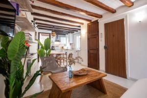 42enf1060 - Authentic &Centric Barcelonian 2BR flat في برشلونة: غرفة معيشة مع طاولة خشبية ومطبخ