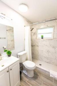 a white bathroom with a toilet and a sink at Cocoanut neighborhood, king bed in Sarasota